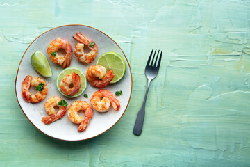 Shrimps, overhead shot with copy space. Cooked shrimp with lime slices, shot from above on a teal table, with a place for text
