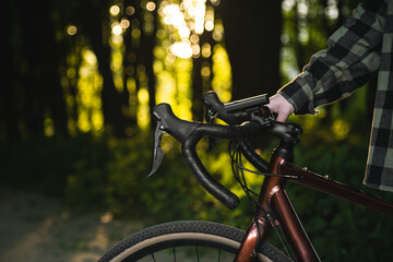 Naklejka na ściany i meble A man with a bicycle in the forest at sunset, the concept of outdoor activity, travel and sports.
