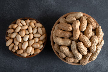 Bowl full of shelled and roasted peeled peanuts on black background,top view
