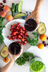 Mom and child are holding glasses with smoothies in their hands.