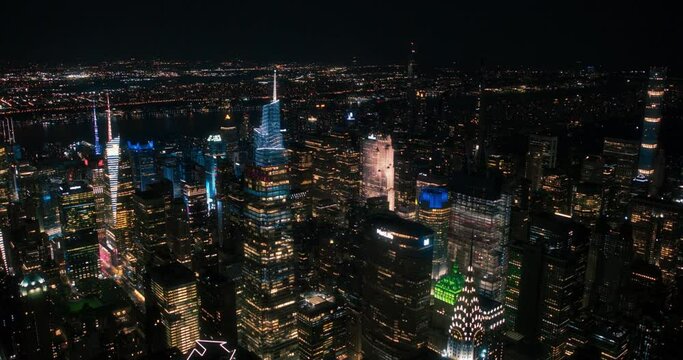 Aerial Footage of Office Buildings at Night. Rooms Have Lights On, Businesspeople and Managers Working Long Hours in New York City. Helicopter Cityscape View of Manhattan in the Evening