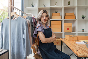 Asian beautiful woman entrepreneur of online sell clothing with laptop and notebook on desk in home office