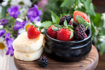 Morning breakfast with cheesecakes and strawberries and blackberries. Cooked breakfast is dietary and healthy
