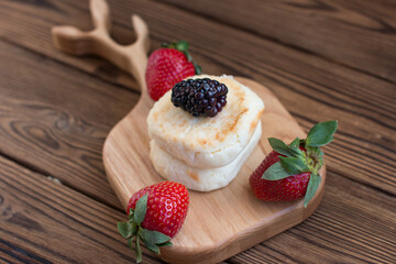 Morning breakfast with cheesecakes and strawberries and blackberries. Cooked breakfast is dietary and healthy