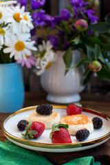 Morning breakfast with cheesecakes and strawberries and blackberries. Cooked breakfast is dietary and healthy