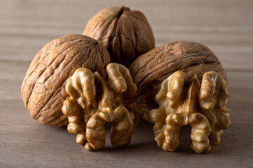 Peeled walnuts and whole walnuts in wooden table
