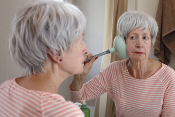 Mischievous senior woman playing with a plunger