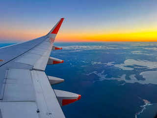 Flying over Sydney NSW airport heading to Melbourne Victoria VIC Australia early winner morning sunrise on the horizon