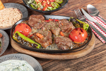 Turkish cuisine Meat Shish. Shish kebab prepared on a barbecue grill on hot coals with grilled vegetables. Meat skewers cooked in butter and stew.