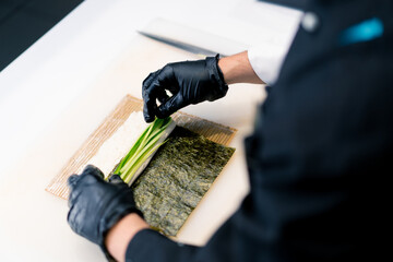 A close-up of the philadelphia rolls process nori cucumber cucumber rice cream cheese and salmon 