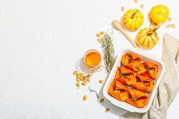 Fototapeta na wymiar Oven baked pumpkin slices with honey, rosemary and seeds. Vegan food, trendy hard light, dark shadow
