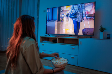Fototapeta na wymiar Woman watching a movie on TV at home