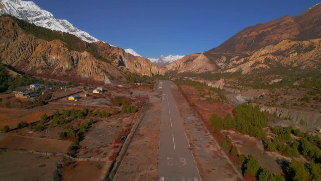Aerial fly over popular Humde airport asphalt runway with mountains background.Transportation Nepal. Annapurna trek, Manang valley, Manang district, Gandaki zone, Nepal Himalayas.