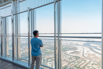 Man enjoying a view of Dubai skyscrapers by standing on the terrace