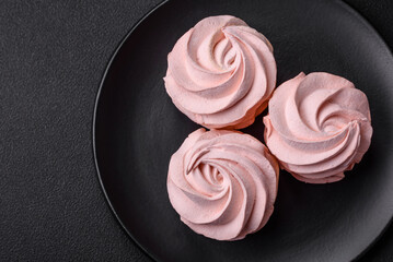 Delicious sweet colored marshmallow on a dark concrete background