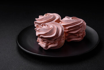Delicious sweet colored marshmallow on a dark concrete background