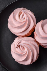 Delicious sweet colored marshmallow on a dark concrete background