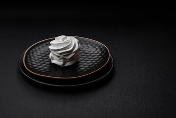 Delicious sweet colored marshmallow on a dark concrete background