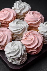 Delicious sweet multi-colored marshmallow on a dark concrete background