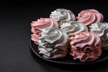 Delicious sweet multi-colored marshmallow on a dark concrete background