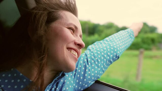 happy girl rides with her hand out window, car rides journey road, portrait woman fun road, Stretching wing shot look fresh travelling cinematic going authentic sunset rays kid arm trip happy job