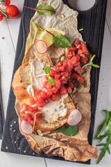 Tuna tartar, bruschetta with cream cheese served on a wooden board, Top view