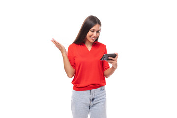 portrait of a cute young european brunette lady in a red t-shirt using online money transfers using a smartphone