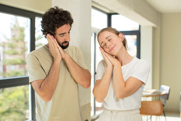 Obraz premium young adult couple lazily early in the morning, waking and looking sleepy, tired and bored