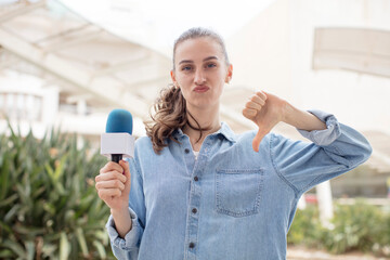 feeling cross,showing thumbs down. presenter with a microphone concept