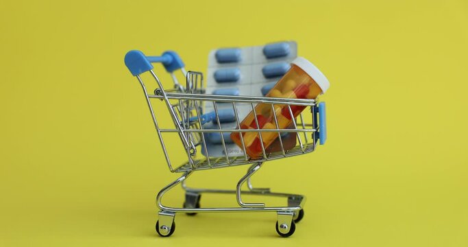 Supermarket trolley of blister tablets in wheelbarrow. Concept of home delivery of medicines
