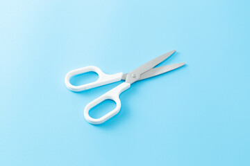青い背景に白いハサミ