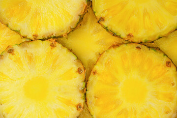 Pineapple juicy yellow slices as a background.