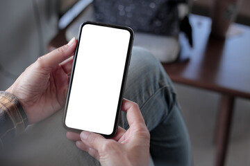 cell phone blank white screen mockup.hand holding texting using mobile on desk at office.background...