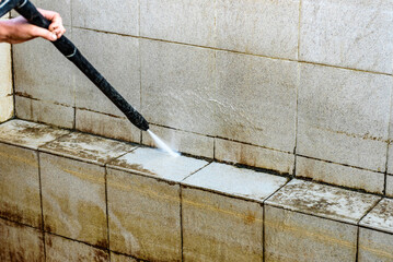 Сleaning a dirty pool with a high-pressure washer.
