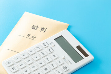 青背景に給料袋と電卓