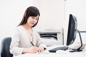 会社で葬儀の準備をする女性