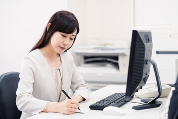 会社で葬儀の準備をする女性