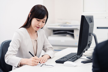 会社で葬儀の準備をする女性