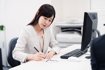 会社で葬儀の準備をする女性
