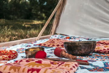 woman plays a Tibetan singing bowl while sitting on a yoga mat. Meditation of a beautiful girl, mental health, Tibetan sound medicine, esotericism, yoga practice