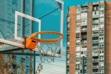 Outdoor basketball backboard and hoop rim with chain net in urban residential district - Powered by Adobe