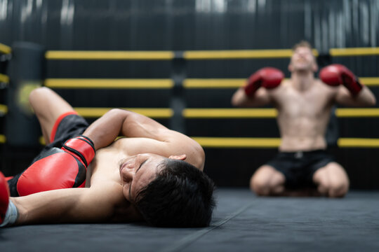 Unconscious Asian boxer lay on floor referee counting down knockout in the ring at fitness gym. Boxing is fighter sport training need body muscular strength, power fist and sweating to become champion