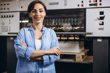 Woman working in printing house with paper and paints