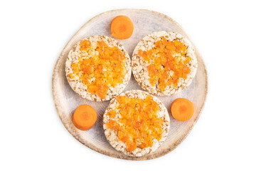 Carrot jam with puffed rice cakes isolated on white. Top view.