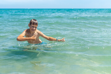 Happy boy swims and dives under water Active healthy lifestyle, water sports, seascape with a child