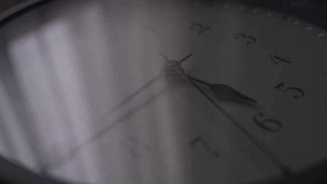 Working wall clock in big cottage filled with silence and darkness. Glass clock reflecting big window with transparent curtains