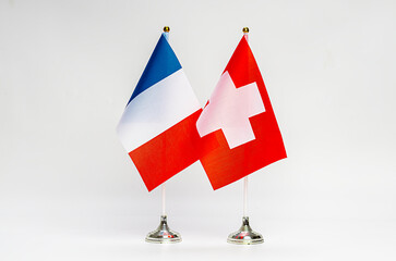 National flags of France and Switzerland on a light background.