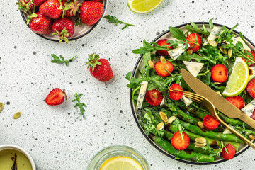 Healthy Green Salad Leaves, Slices of Fresh Strawberries. Concept healthy and balanced eating. place for text, top view