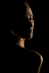 Sensual portrait silhouette of beautiful woman in backlight on a black background