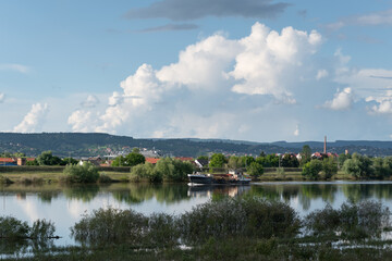 Fototapeta na wymiar Ship sail in Sava river and big cloud in sky, landscape with river and cumulus cloud